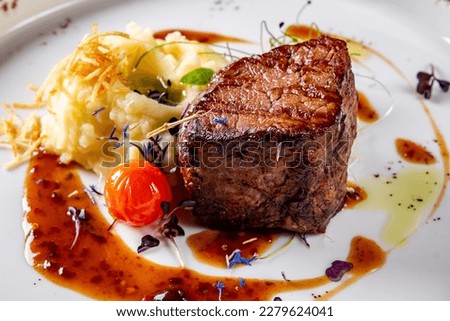 Grilled beef steak filet mignon with potato and sauce in plate Royalty-Free Stock Photo #2279624041