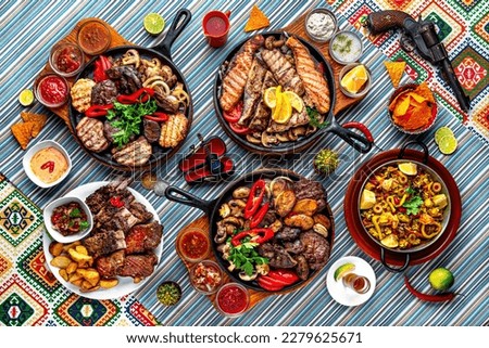 Traditional mexican food. The assortment of mega grills in hot pans of fish, beef, chicken, lamb. Colorful Food Table Celebration Delicious Party Meal Concept. 