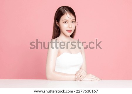 Young Asian woman long hair with natural makeup on face have plump lips and clean fresh skin on isolated pink background. Portrait of cute female model in studio. Facial treatment, Cosmetology. Royalty-Free Stock Photo #2279630167