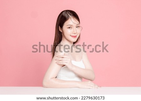 Young Asian woman long hair with natural makeup on face have plump lips and clean fresh skin on isolated pink background. Portrait of cute female model in studio. Facial treatment, Cosmetology. Royalty-Free Stock Photo #2279630173