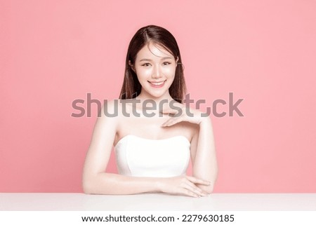 Young Asian woman long hair with natural makeup on face have plump lips and clean fresh skin on isolated pink background. Portrait of cute female model in studio. Facial treatment, Cosmetology. Royalty-Free Stock Photo #2279630185