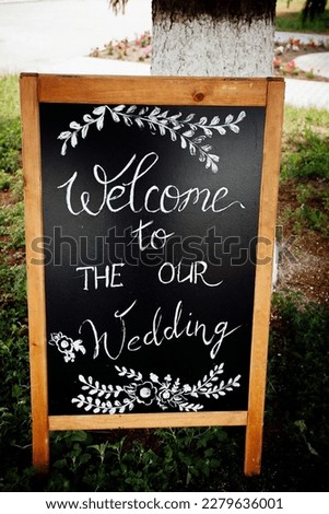 A wooden sign with a wedding invitation for holiday guests. Creative image for your design or illustrations.