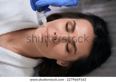 Close up photo of nurse doing face resurfacing procedure