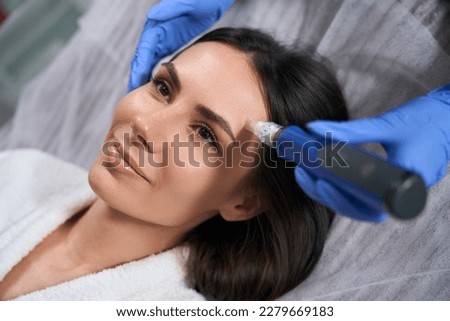 Top view of female holding device for microneedle mesotherapy Royalty-Free Stock Photo #2279669183