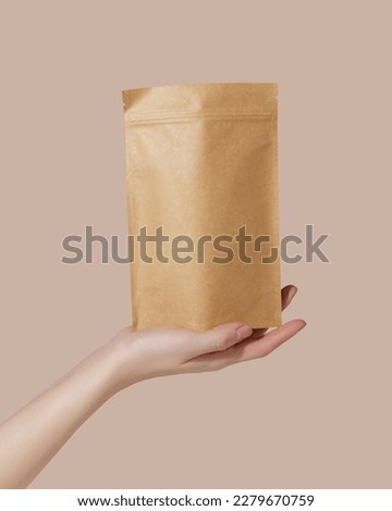 Woman's hands hold cardboard packages for tea or snacks on a pink background. Tea branding and packaging mockup. Royalty-Free Stock Photo #2279670759