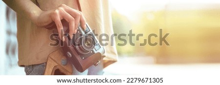 woman holding vintage camera in street
