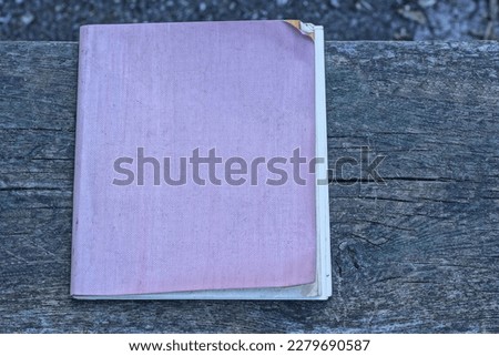one old notebook with a lilac cover lies on a gray table