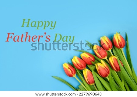 Card with the inscription Happy Fathers Day with tulips on a blue background.Concept holiday, congratulation, design, gift, discounts, party, day off, family,text, moc-up, copy space,celebration,love. Royalty-Free Stock Photo #2279690643