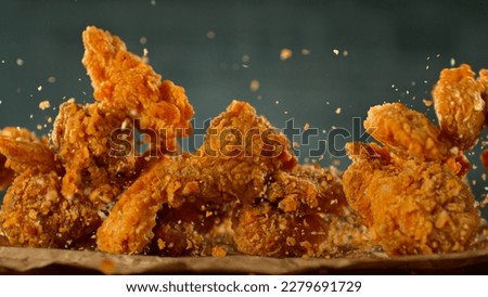 Freeze Motion Shot of Flying Fresh Fried Chicken Wings or Strips, Close-up Royalty-Free Stock Photo #2279691729