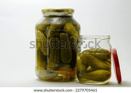 Two jars of canned pickles, on a white background, one jar is closed, the second is open, the lid is next to the jar. Royalty-Free Stock Photo #2279705461