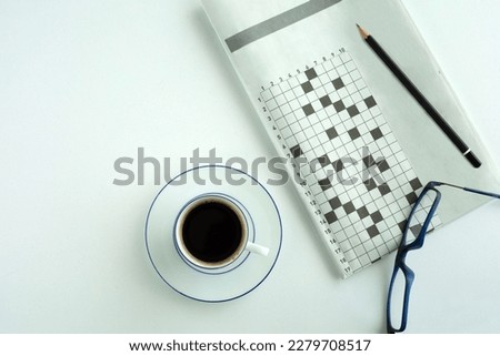 crossword paper with eyeglasses and coffee cup Royalty-Free Stock Photo #2279708517