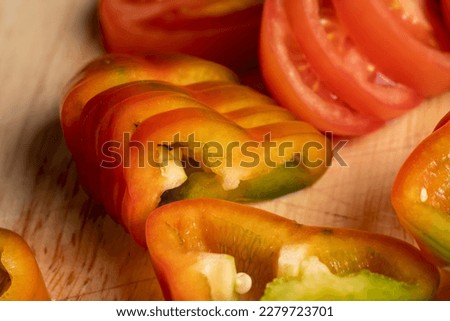Fresh ripe bell pepper sliced on a board, red green pepper sliced on a board together with seeds