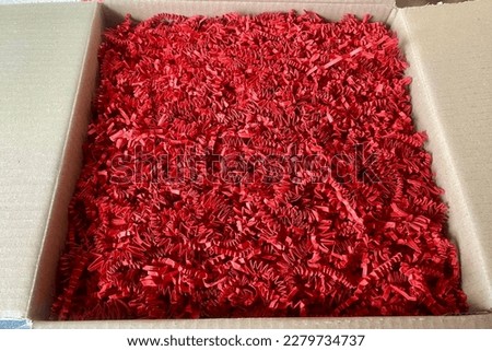 Box full of red package filling paper only, shredded zig zag  Royalty-Free Stock Photo #2279734737