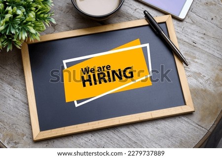 WE ARE HIRING message is written on the black chalkboard. Opening advertisement concept Royalty-Free Stock Photo #2279737889