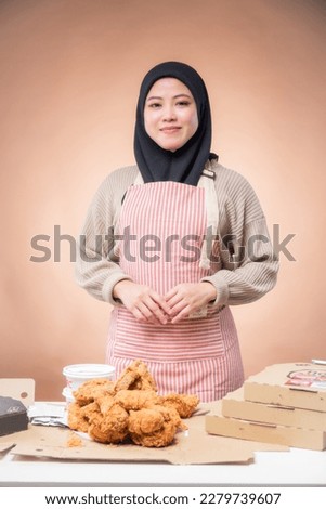 hungry islamic woman looking, eating halal fried chicken wingstick; concept of delicious halal food, fast food, health care, eating habit, crispy tasty fried chicken burger; asian muslim woman model Royalty-Free Stock Photo #2279739607