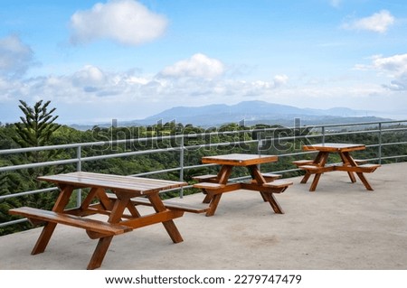 Picnic tables with cloudy skies and mountains in the horizon