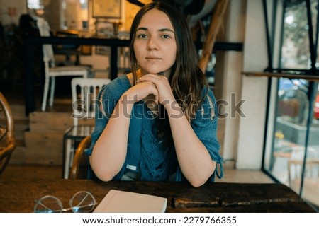 young girl at a table in a cafe with a notebook. High quality photo