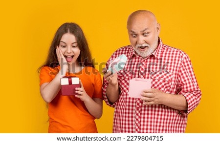 shocked kid and granddad with present box for anniversary