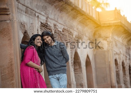 Happy young Indian couple visiting monument