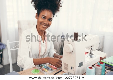 Happy beautiful African American woman fashion designer clothes working with sewing in own dressmaking studio or boutique	 Royalty-Free Stock Photo #2279827419
