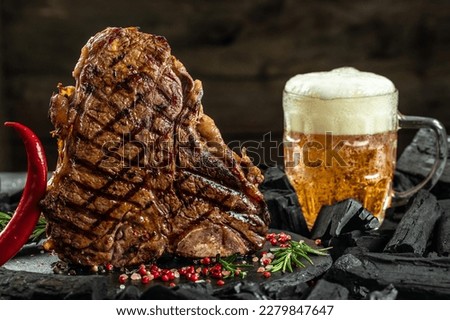 grilled meat and mug of beer. T-bone or porterhouse beef meat Steak. Restaurant menu, cookbook recipe top view. Royalty-Free Stock Photo #2279847647