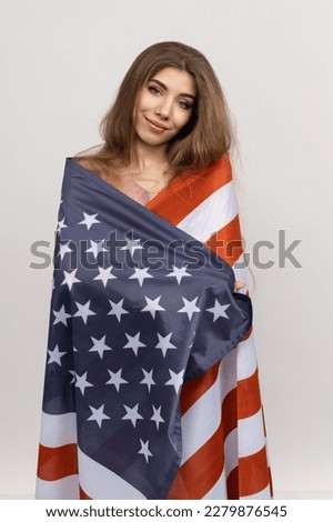 Photograph captures a moment of pride and devotion as a woman clasps the American flag tightly in her hands. The clean white background