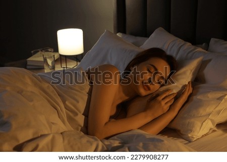 Beautiful young woman sleeping in bed at night Royalty-Free Stock Photo #2279908277