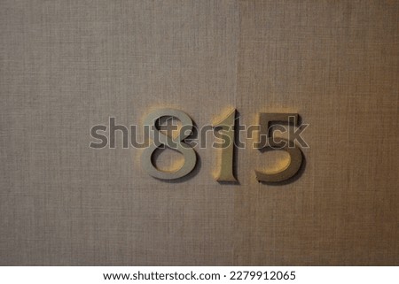 Gold toned digits 815 on a wall