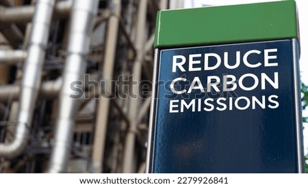 Reduce Carbon Emissions on a sign in front of an Industrial building	
