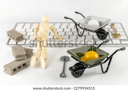 Construction tools such as drawing dolls, keyboards and toys. Image of overworked and underpaid IT professional