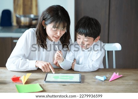 mother and child playing with a tablet PC