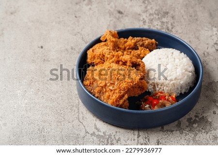 Ayam Geprek is an Indonesian Food crispy fried chicken with hot and spicy sambal Chili Sauce. Royalty-Free Stock Photo #2279936977