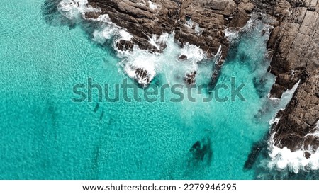 Aerial picture of blue water and rocks. Location Bremer Bay in South-west Australia. Drone view of ocean, rocks, small waves and foamy water.