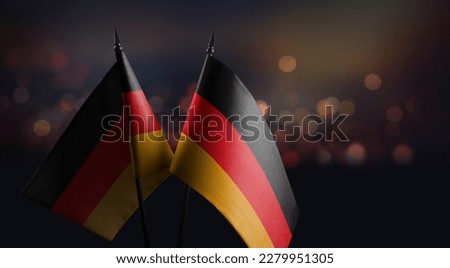Small flags of the Germany on an abstract blurry background.