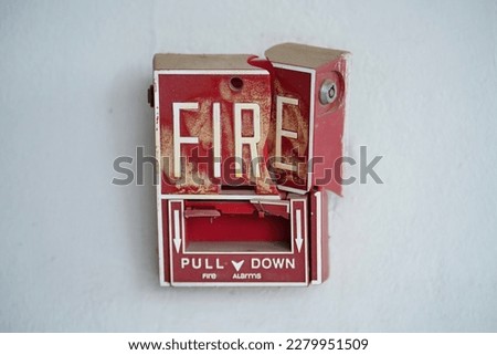 Old and broken fire alarm on the wall gray