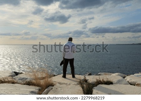 Silhouettes of people on the streets in the city and on the coast near the sea or lake