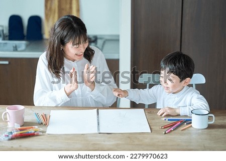 A mother who praises a child playing in the room Royalty-Free Stock Photo #2279970623