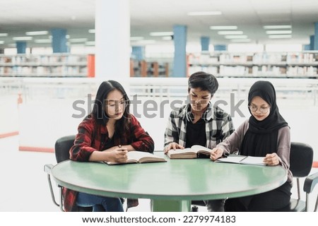 Group of students reading books and preparing to exam in library