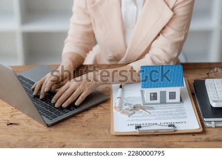 Young businesswoman or real estate agent signing contract for home insurance, real estate investment advisor, property insurance. Real estate agent offers a house.