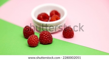 A photo of raspberries on different colorful backgrounds. Red, green, violet, pink. Structure, texture, close up og macro picture. Fresh red fruits.