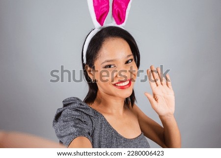 Brazilian woman, northeastern, wearing bunny ears, photo for Easter. taking self portrait with mobile phone, selfie.