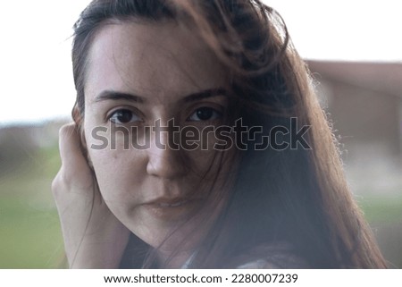 female sensitivity.Gentle girl.Close-up portrait of a woman.Emotions of calmness and sadness.Close-up of a girl.Brown-eyed girl.Long hair blowing in the wind.Sensual portrait.Ukrainian.Problem skin Royalty-Free Stock Photo #2280007239