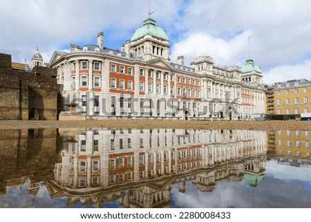 Old Admiralty Building reflects in a puddle on Horse Guards Parade in London