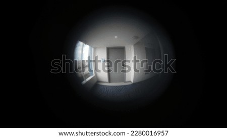 Portrait peephole on the hotel room door, which is out of focus pointing right at the door of the room in front of him. Royalty-Free Stock Photo #2280016957