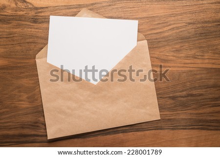 Blank paper and envelope on wooden background  
