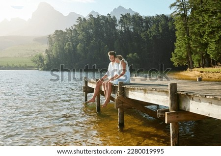 Love, happy and deck with couple at lake for bonding, romance and affectionate date. Nature, travel and holiday with man and woman cuddling on boardwalk in countryside for view, summer and vacation