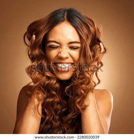 Curly, hair or excitement with a model woman on a brown background in studio for natural haircare. Smile, salon and hairstyle with a happy young female feeling excited by keratin or shampoo treatment