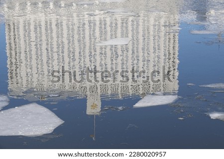 Ice drift on the Moscow River, reflection of the Government House on Krasnopresnenskaya embankment in the water, closeup of photo