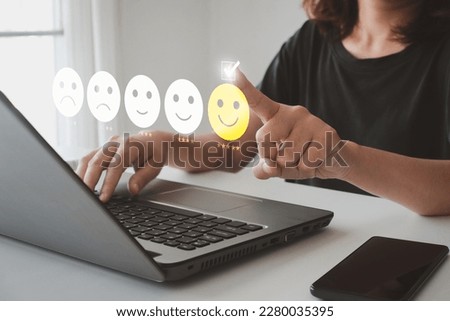 Client's hand ticked the happy face smile face, Customer service evaluation and satisfaction survey concept. User give rating to service experience on online application for Customer review feedback. Royalty-Free Stock Photo #2280035395
