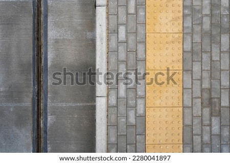 top view of yellow border line on stone pavement near tram track, tramway station in city, warning sign in public place Royalty-Free Stock Photo #2280041897